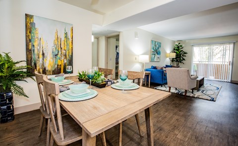A dining room with a wooden table and chairs.