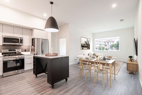 a kitchen with a large island and a dining room with a table and chairs