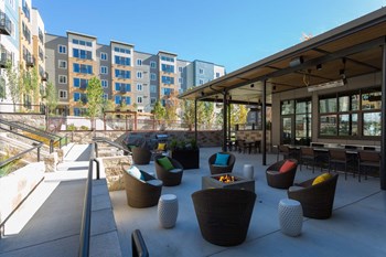 Outdoor Living Area Including Bbq'S And Fire Pits at Tivalli Apartments, Lynnwood, WA, 98087 - Photo Gallery 13
