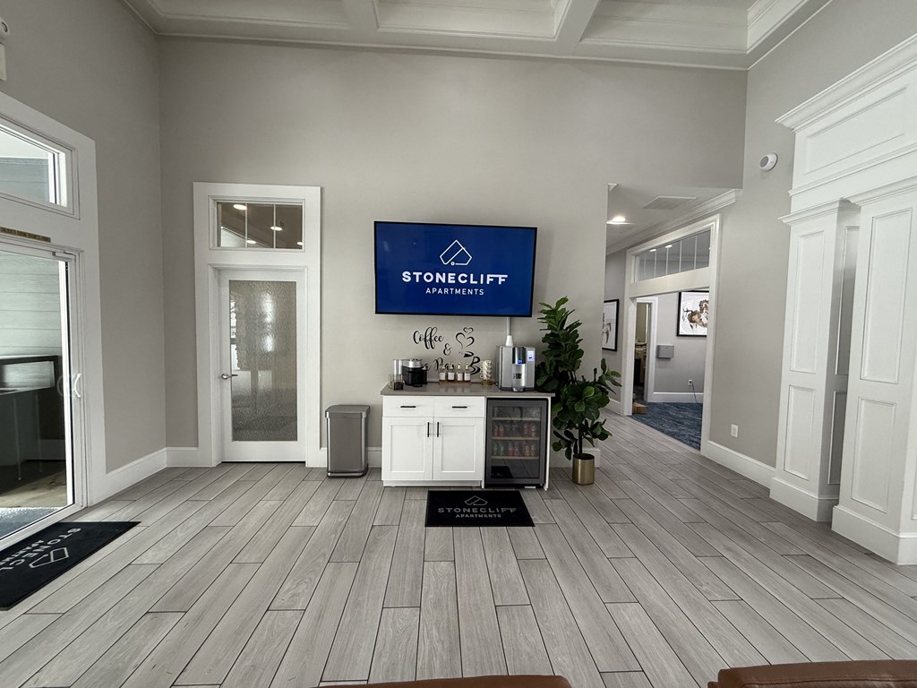 Stonecliff Apartments lobby with a reception desk and a plant.