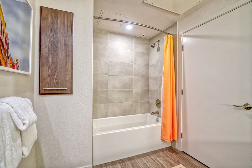 a bathroom with a shower and a tub and a white door