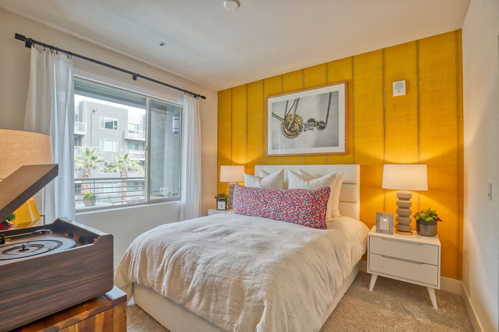 a bedroom with an orange accent wall and a bed