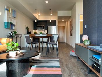 a living and dining room area with a table and chairs and a kitchen