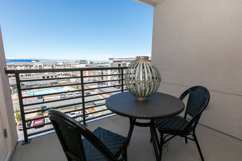a balcony with a table and chairs and a view of the city