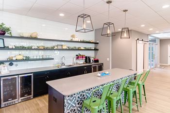 a kitchen with a long counter and green chairs