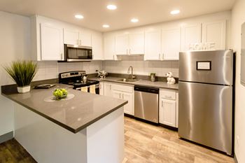 a kitchen with stainless steel appliances and white cabinets