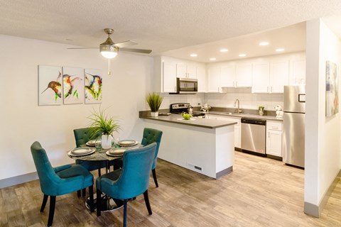 A modern kitchen with a dining table set for two.