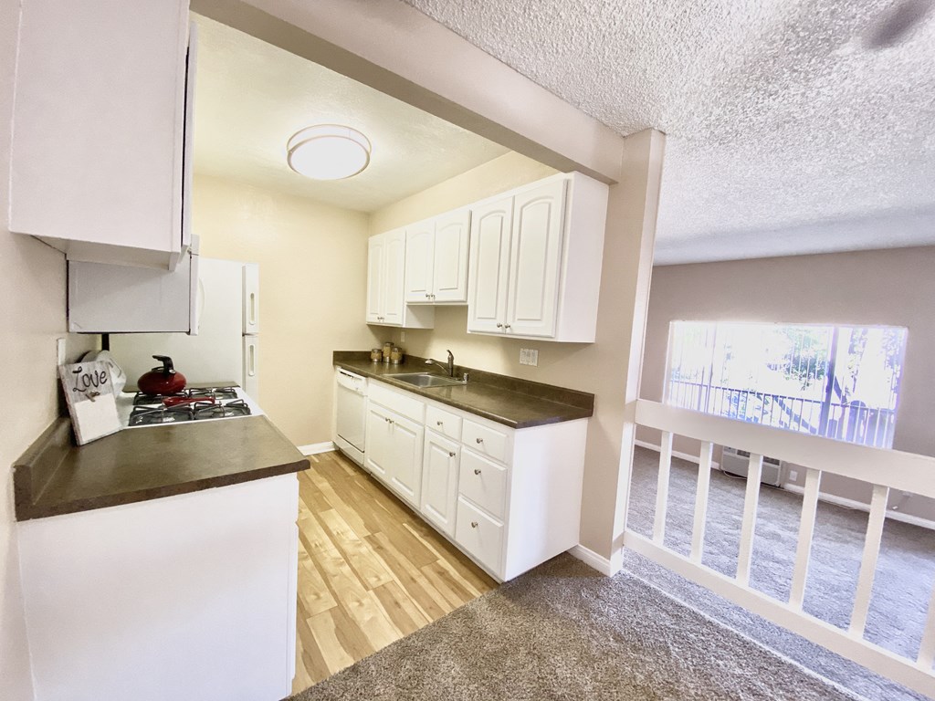 the view of a kitchen with white cabinets and a window