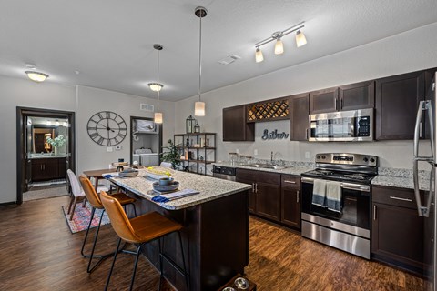 a kitchen with stainless steel appliances and a table with chairs