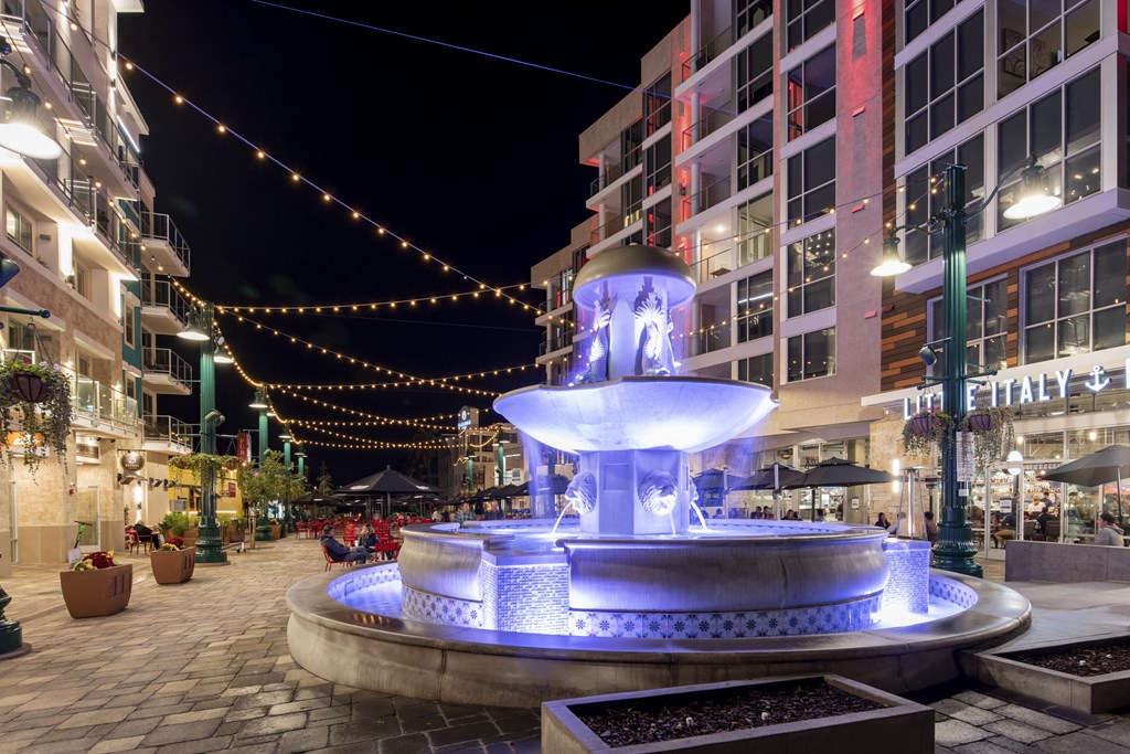 a fountain in the middle of a city street at night