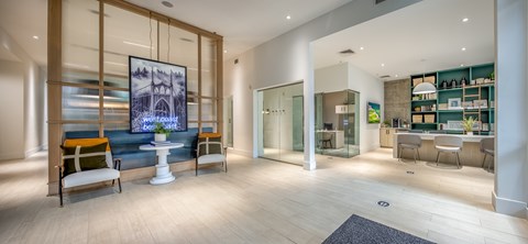 A modern living room with a large painting on the wall and a kitchen area in the background.