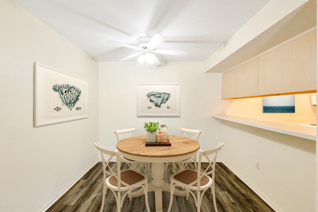 a dining room with a table and chairs and a ceiling fan