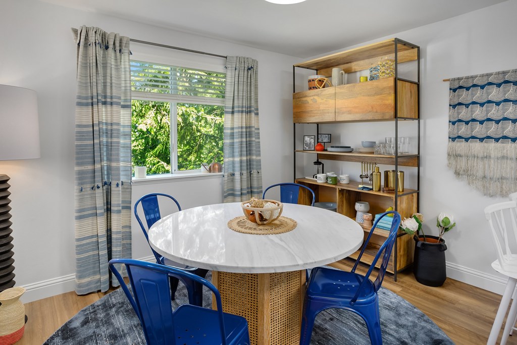 A dining room with a round table and blue chairs.
