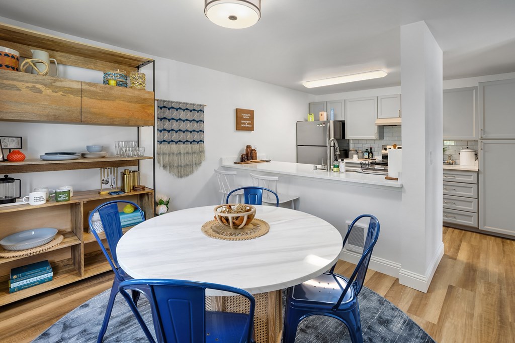A kitchen with a dining table and chairs.