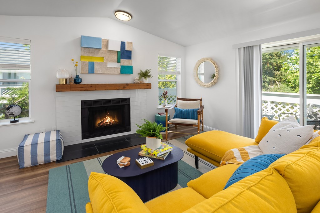 A living room with a fireplace and a yellow couch.