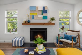A living room with a fireplace and a painting above it.