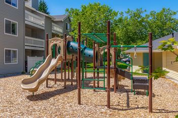 A playground with a slide and a green canopy.