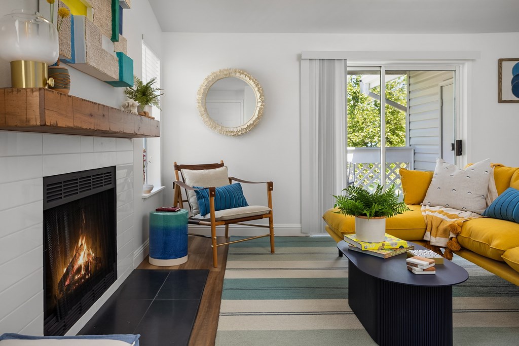 A living room with a fireplace and a yellow couch.