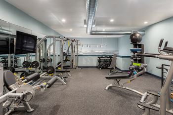 A gym with a variety of equipment including weights and machines.