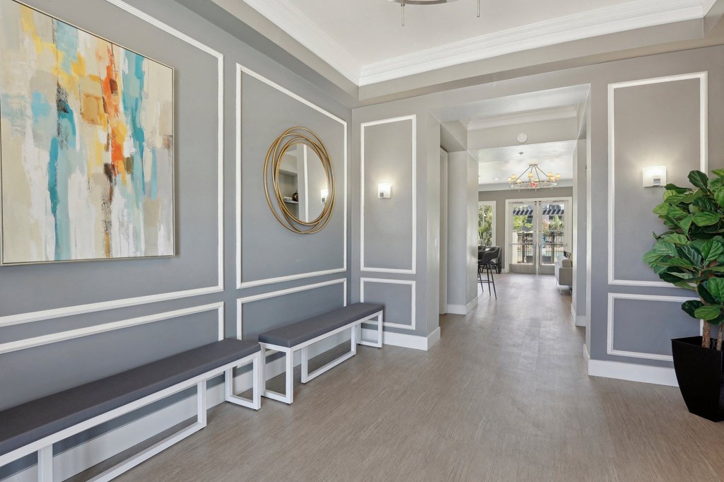 a long hallway with benches and a painting on the wall