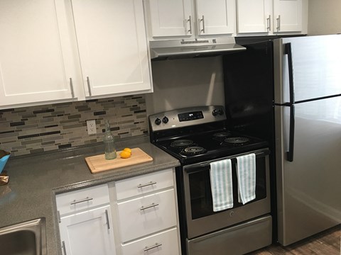 a kitchen with stainless steel appliances and white cabinets
