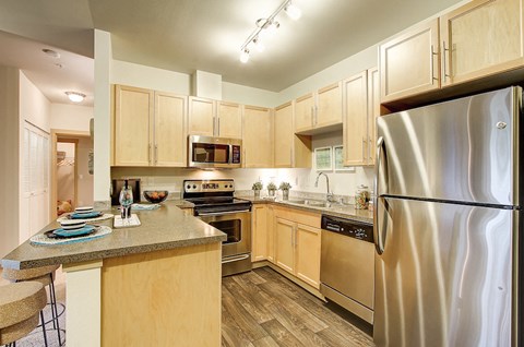 a kitchen with stainless steel appliances and wooden cabinets