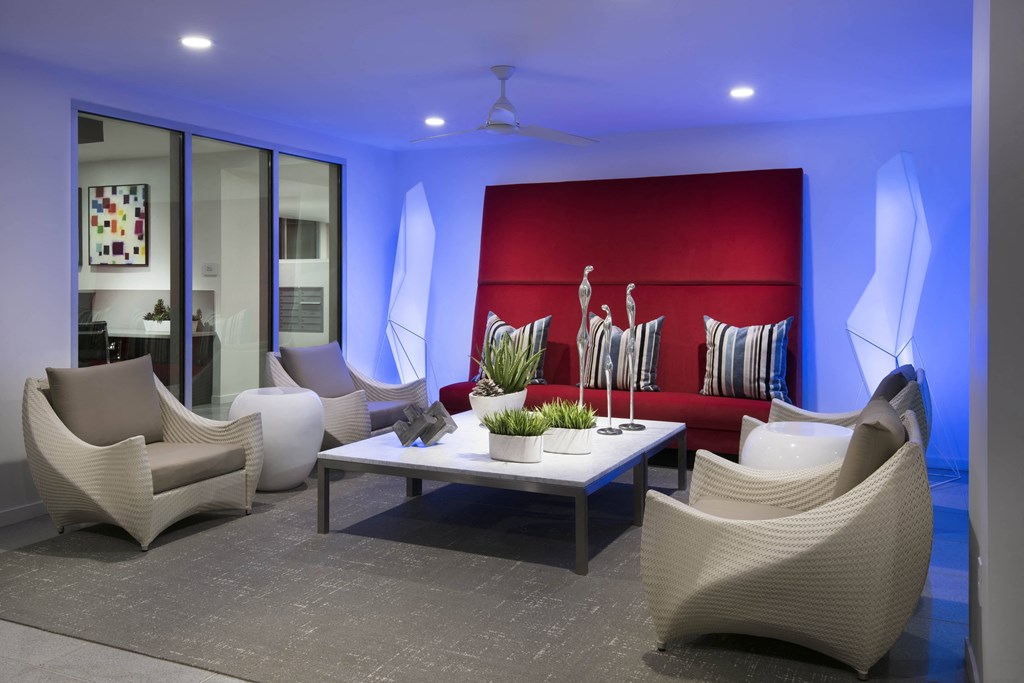 a lounge room with white chairs and a red couch