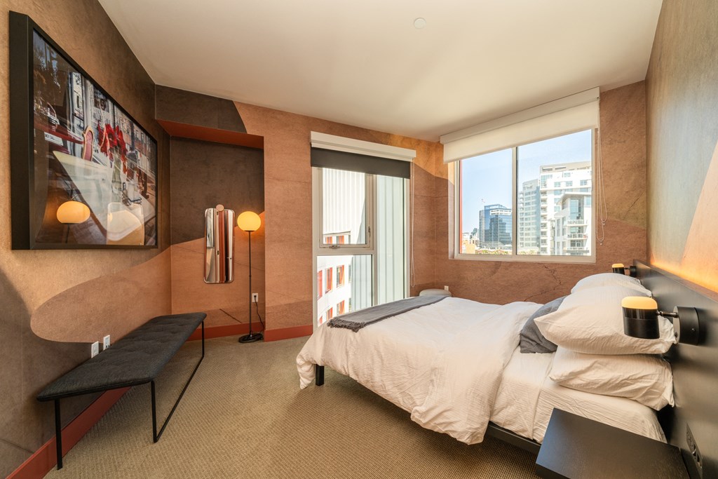 A bedroom with a large bed and a view of the city.