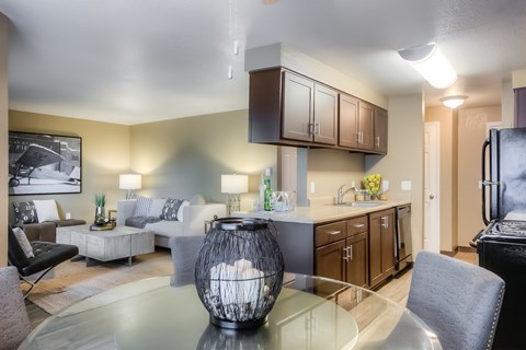 A modern living room with a glass table and a large vase.