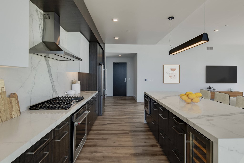 a large kitchen with marble counter tops and wooden floors