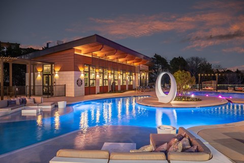 A large outdoor swimming pool with a white sculpture in the middle.