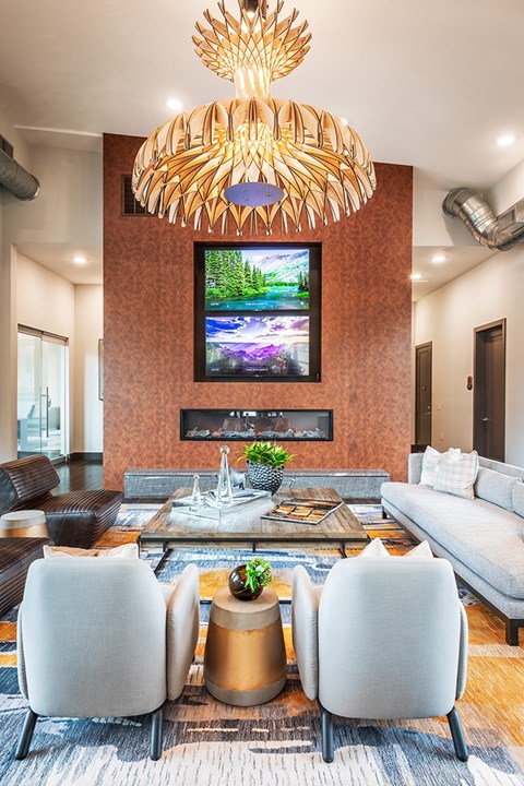A modern living room with a large TV and a unique chandelier.