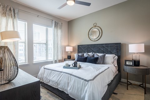 A bedroom with a large bed and a ceiling fan.