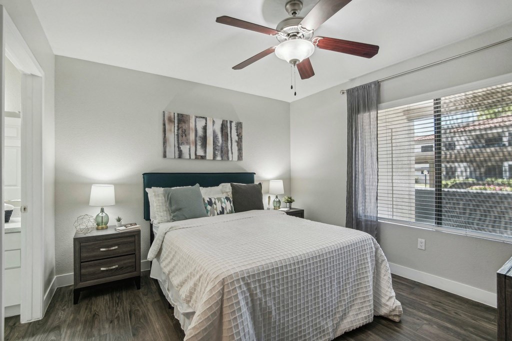 a bedroom with a bed and a ceiling fan