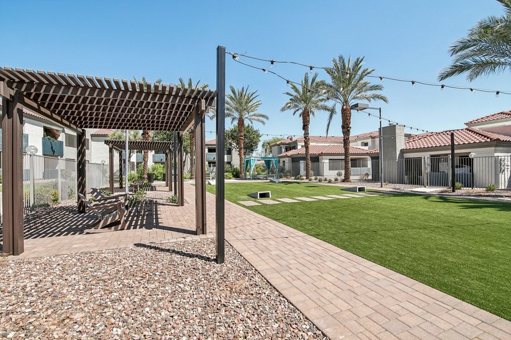 the yard of a house with a lawn and palm trees