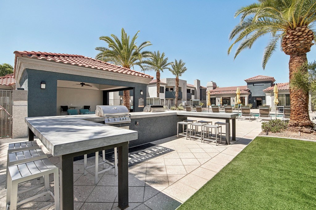 a patio with tables and chairs and palm trees