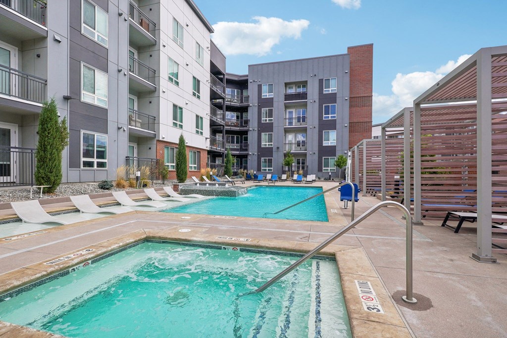 a swimming pool with an apartment building in the background