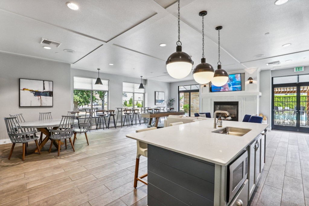 a communal kitchen and dining room with tables and chairs and a fireplace
