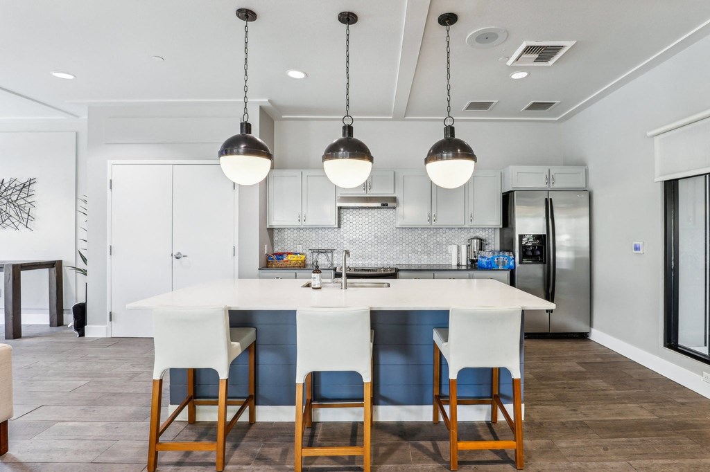 a kitchen with a large island with four chairs in front of it