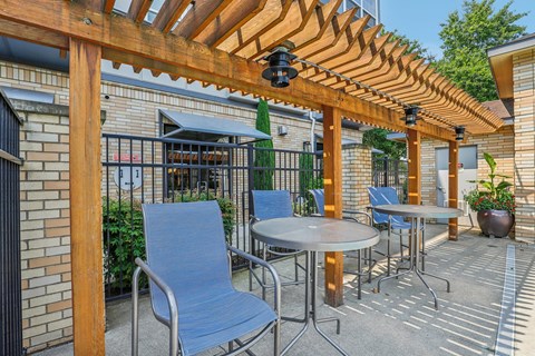 a patio with tables and chairs and a pergola