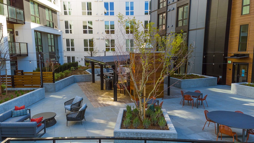 a courtyard with a table and chairs in front of a building