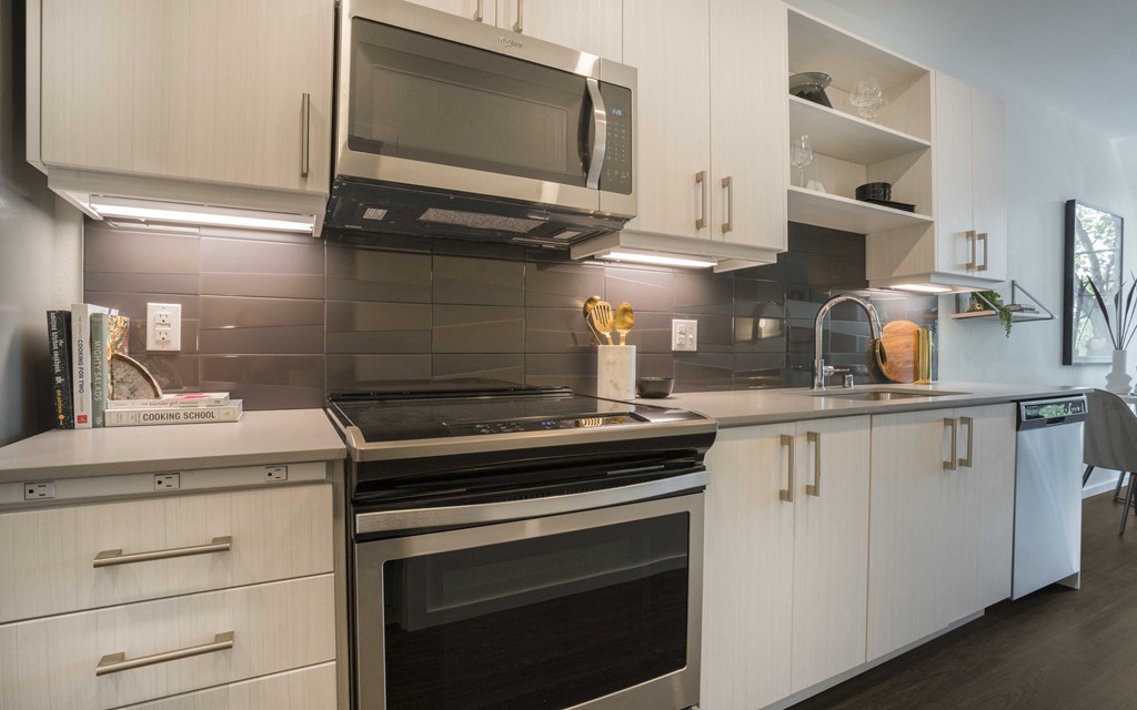 a kitchen with white cabinets and a stove and a microwave
