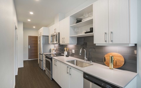 a kitchen with white cabinets and stainless steel appliances and a sink