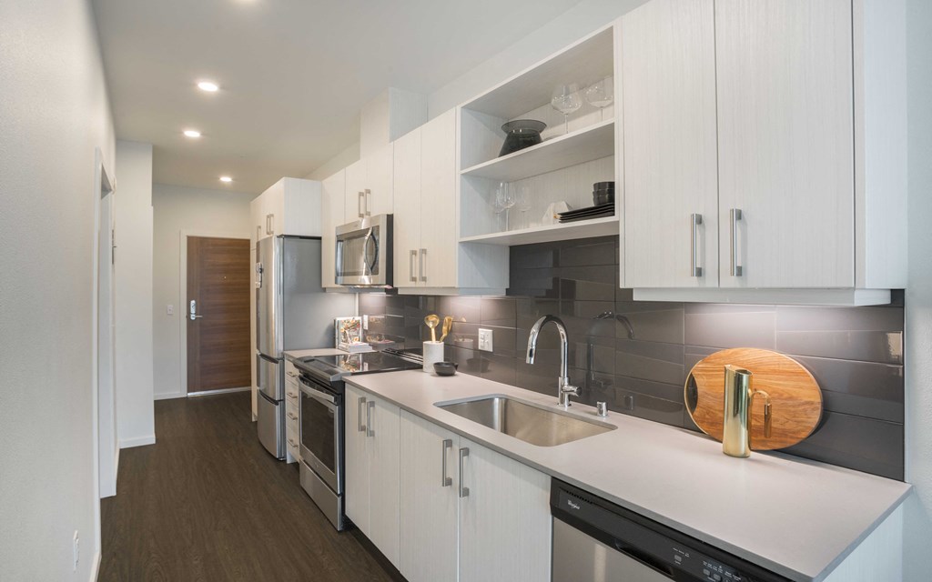 a kitchen with white cabinets and stainless steel appliances