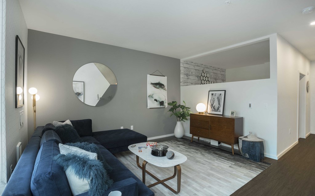 a living room with a blue couch and a white coffee table