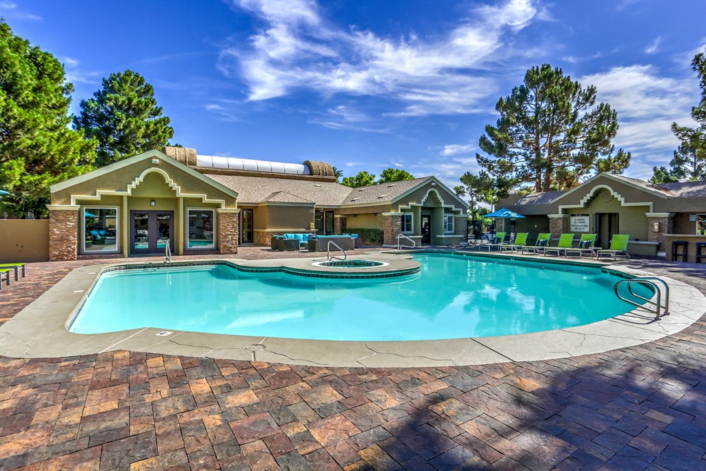 a large swimming pool with a house in the background