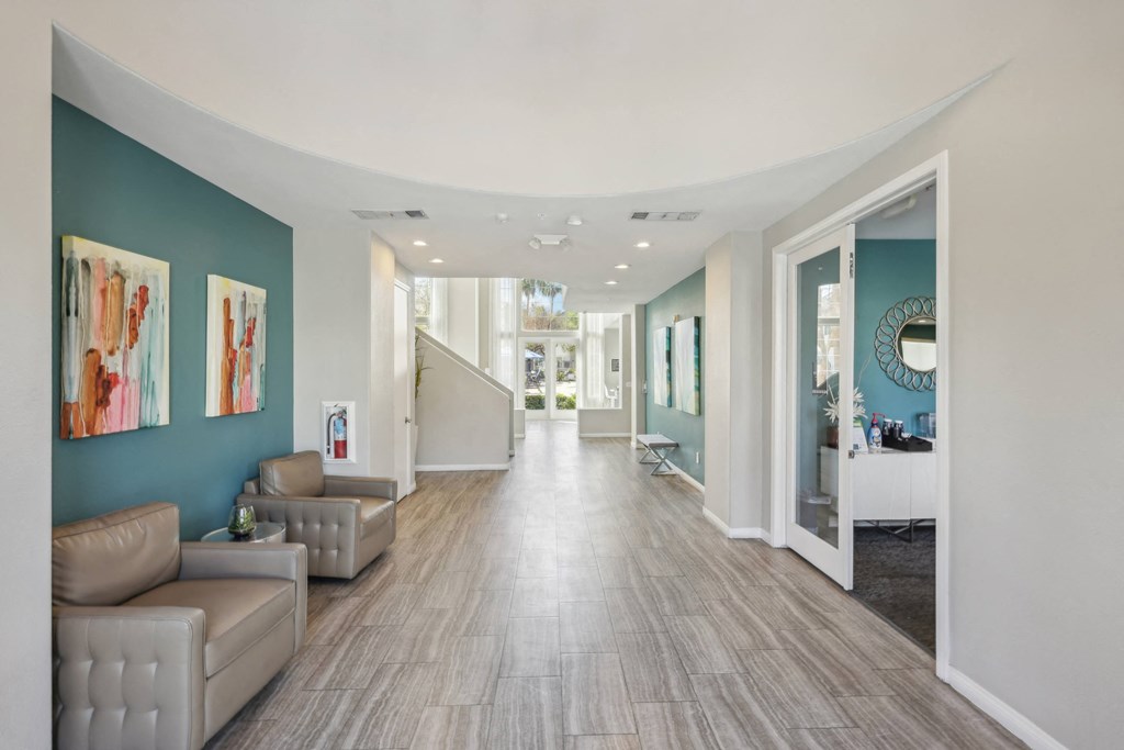 a long hallway with couches and a mirror on the wall