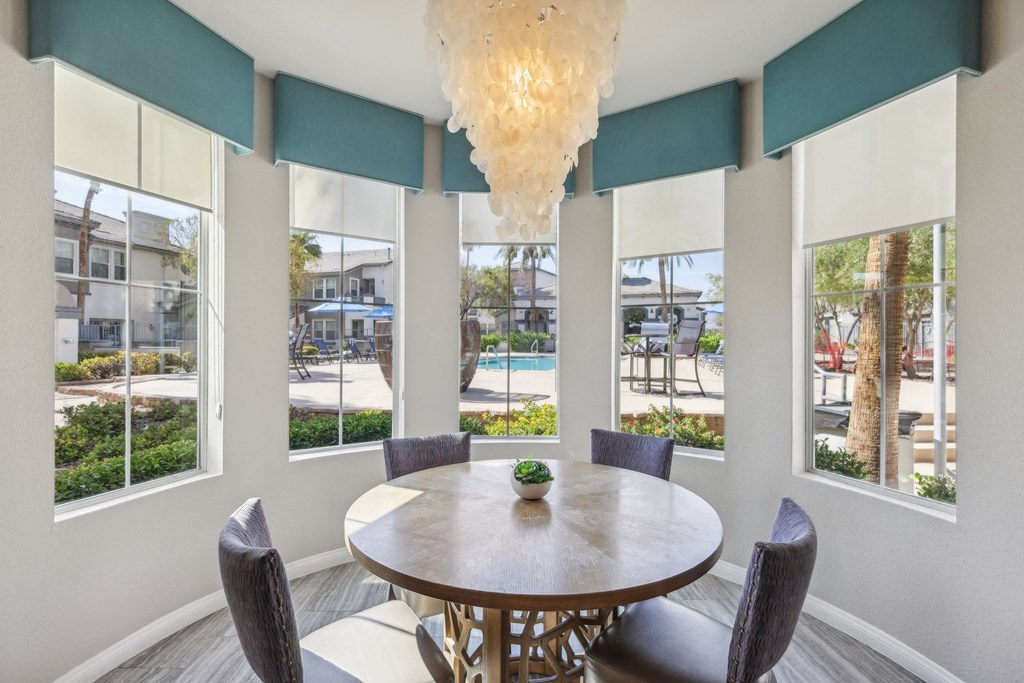 a dining area with a table and chairs and windows