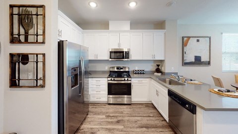 a kitchen with white cabinets and stainless steel appliances