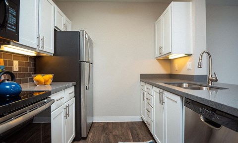 a kitchen with white cabinets and a stainless steel refrigerator
